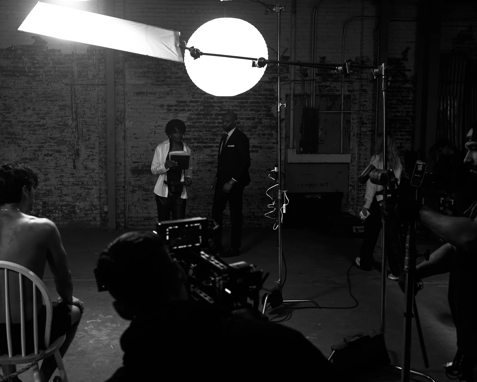 Actors and crew beneath a large diffusion panel and round light. The Hitman’s Dalliance.