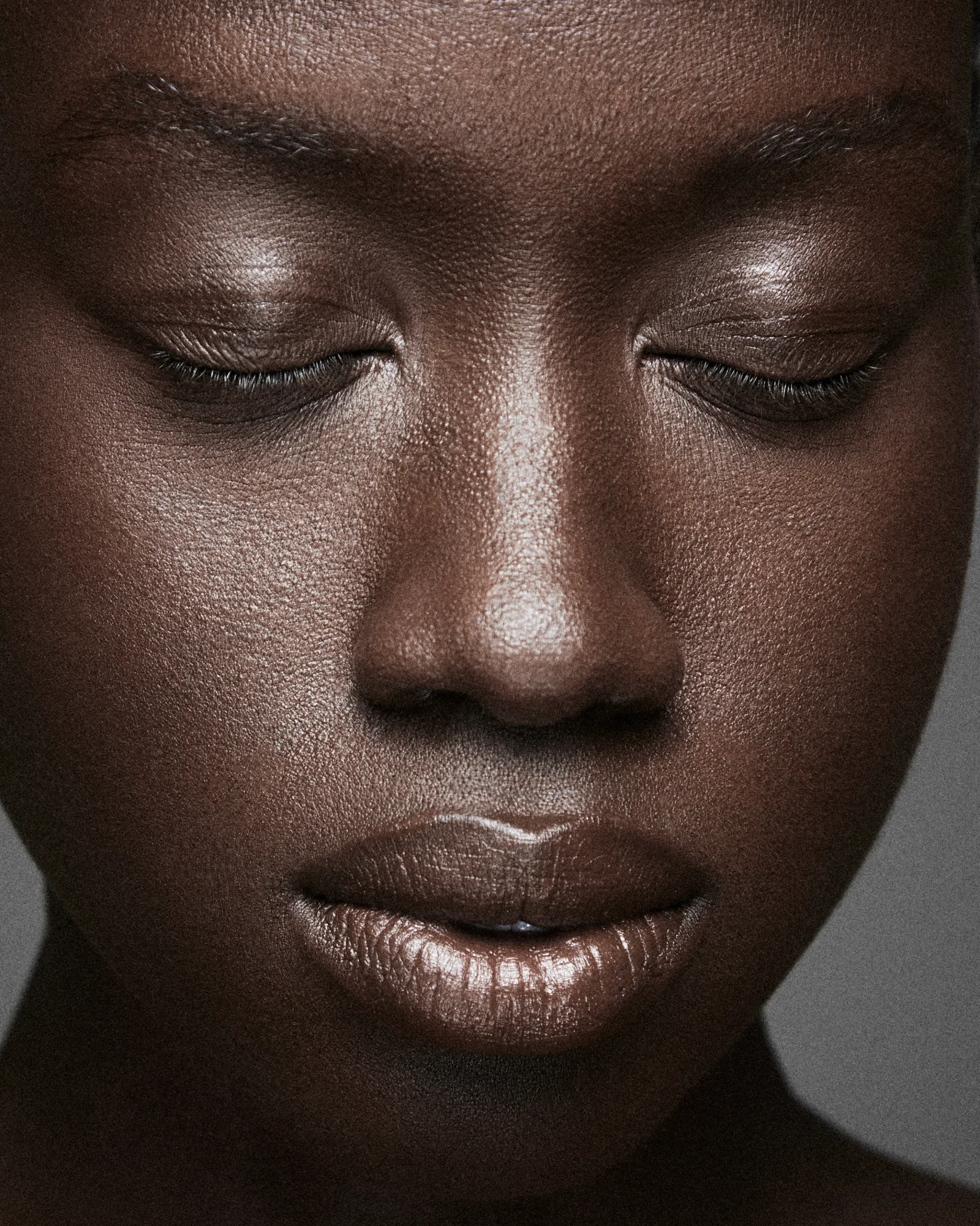A close beauty portrait with closed eyes and soft silver eye makeup.
