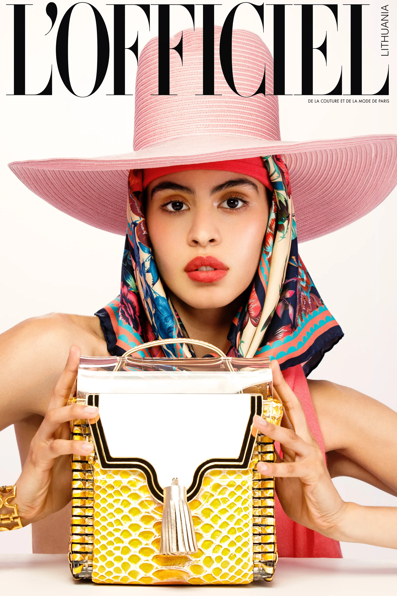 L’Officiel Lithuania page with a pink hat, patterned scarf and yellow handbag.
